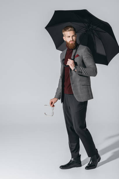 istock attractive young man with umbrella 847104964