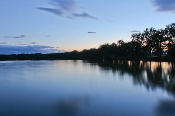 istock Sunset on pond with trees silhouette and orange sky, long exposure, Czech landscape 847116664