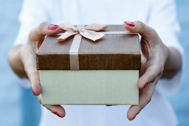 istock Woman hand holding brown gift box 847136926