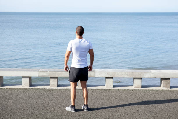 istock Muscular Athlete Looking at Sea on Bridge 847137714