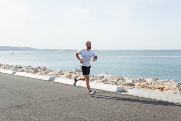 istock Serious Sporty Young Man Running Fast at Seaside 847137860