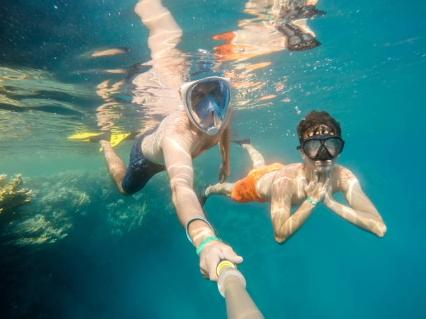 istock father and son snorkel in shallow water on coral fish 847143742