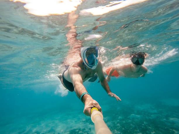 istock father and son snorkel in shallow water on coral fish 847143800
