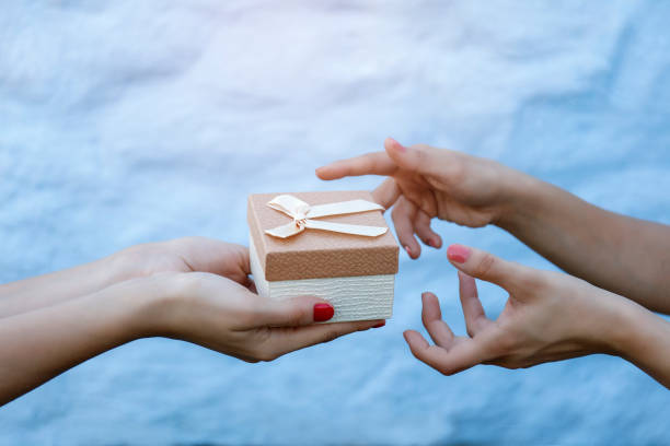 istock Closeup hands giving and receiving gift box 847152380