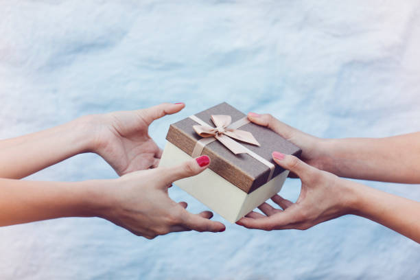 Closeup hands giving and receiving gift box