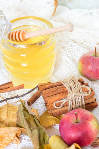 istock Honey and apples and cinnamon on wooden table 847155728