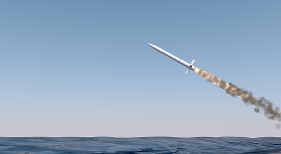 An intercontinental ballistic missile launching across the ocean on a blue sky backgrund - 3D render