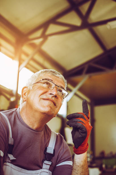 istock Senior man in workshop. Man sitting after work with a raised finger looking up. 847159820