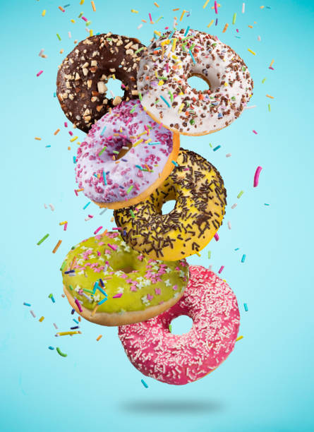 istock Tasty doughnuts in motion falling on pastel blue background 847160062