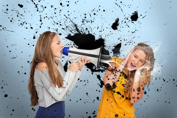 istock Girl shouting at another through megaphone 847160102