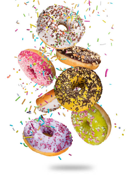 leckere donuts in bewegung fallen auf weißem hintergrund - streuen fotos stock-fotos und bilder