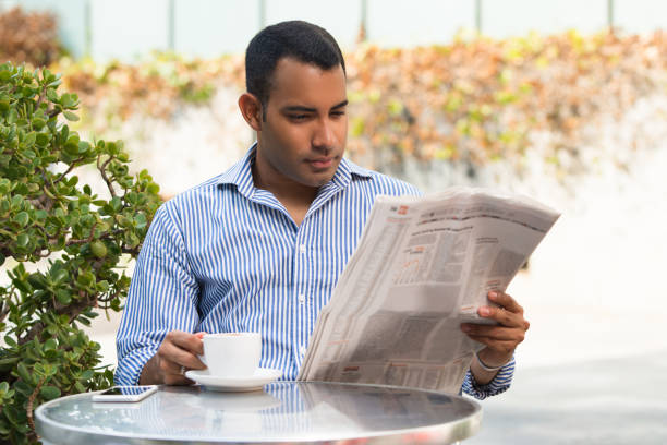 istock Concentrated Latin Young Man Reading News in Cafe 847161234
