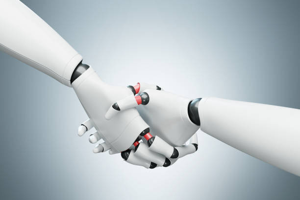 istock Two white robots shaking hands, gray close up 847164198