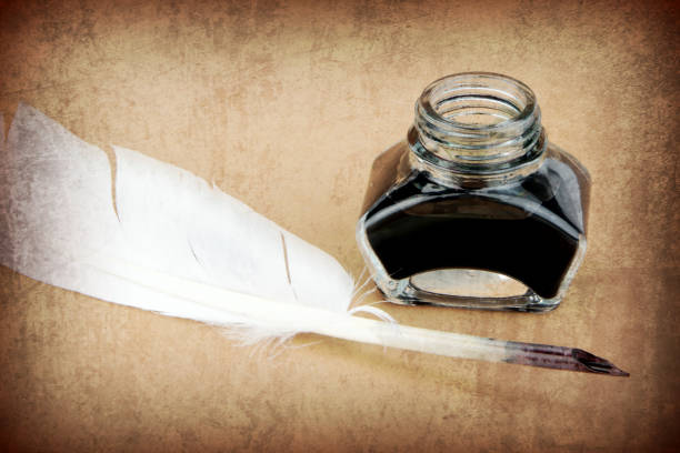 istock Quill pen and ink bottle on brown background. 847169214