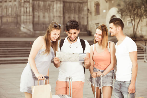 istock four traveling young people searching for direction using paper map in European town 847169426