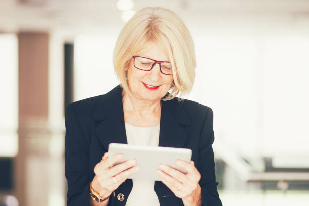 istock Smiling Senior Business Lady Using Tablet in Lobby 847172316