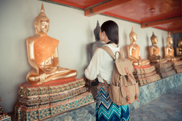 istock female backpacker praying in front of buddha 847176234