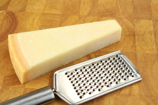 istock Parmesan cheese and grater on kitchen board. 847176246