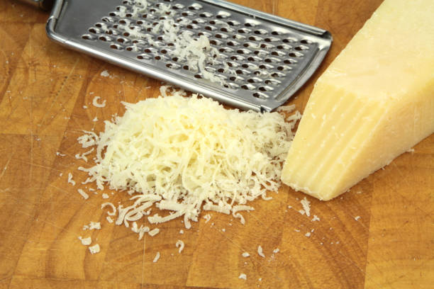 istock Parmesan cheese and grater on kitchen board. 847176276