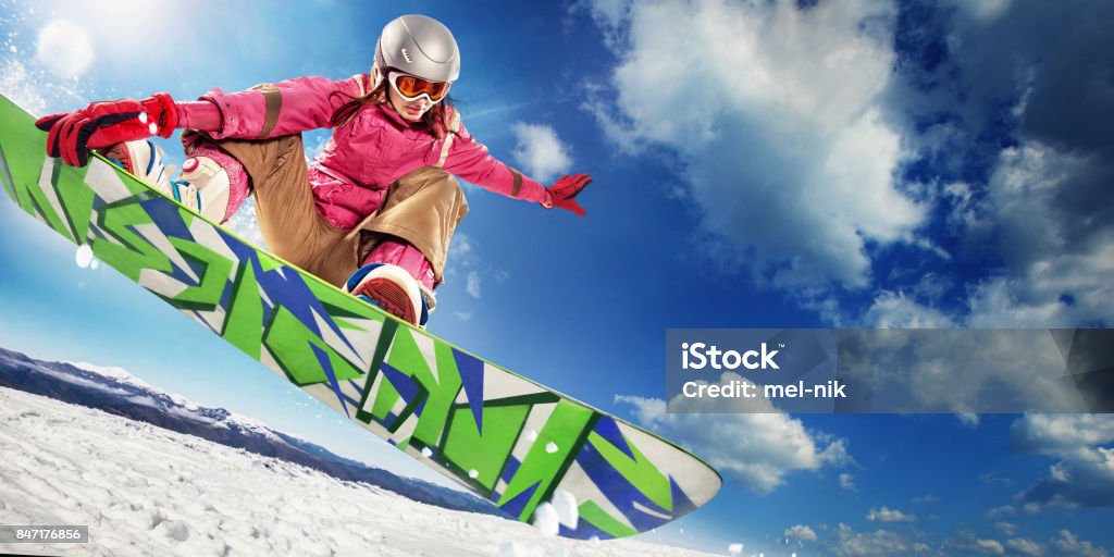 Sports background. Snowboarder jumping through air with deep blue sky in background. Winter sport in the mountains. Snowboarding Stock Photo