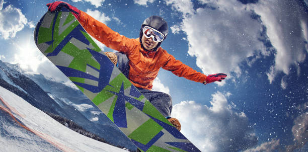 fondo del deporte. deporte de invierno. snowboarder salta a través del aire con el cielo azul de fondo. - snowboarding extreme sports action snowboard fotografías e imágenes de stock