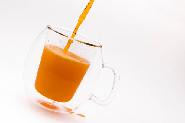 A glass of orange soda on a white background