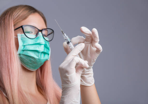 istock Young pretty nurse with syringe needle isolated on grey background 847177596