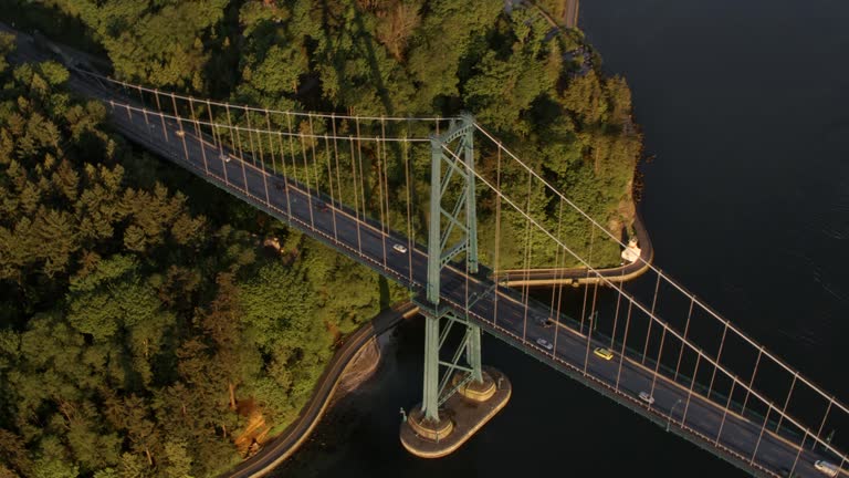 AERIAL Above the Lions Gate Bridge at Stanley Park in the early morning sun