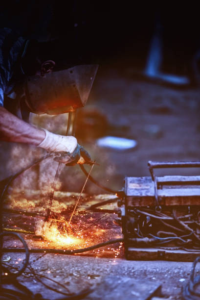 istock Worker with protective welding metal on construction site.A person angle grinding on metal. Working with a welding machine 847186868