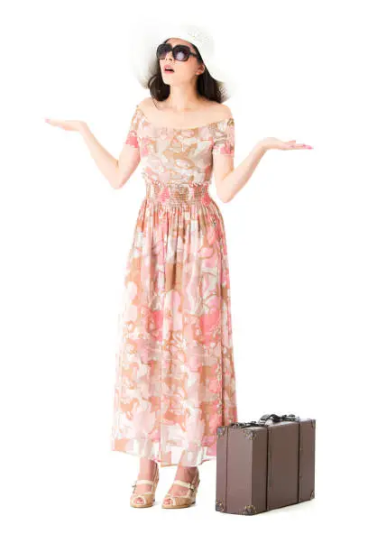 elegant sweet woman feeling unhappy showing annoyed posing standing on white background and wearing travel dress with retro style luggage suitcase.