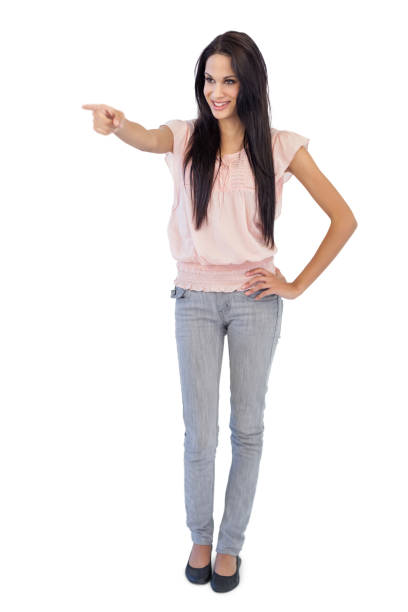 istock Smiling young woman pointing at something 847190654