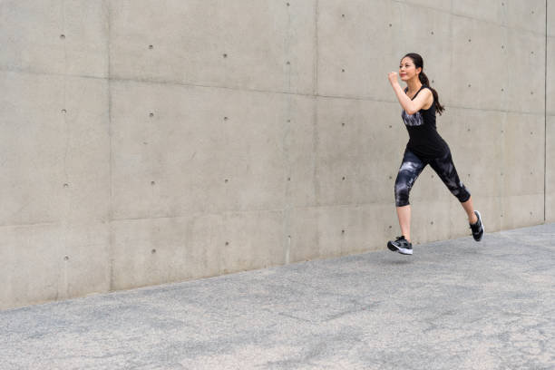 istock young female jogger jogging on gray background 847192186