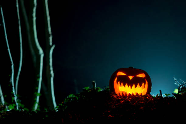 istock Illuminated Halloween Pumpkin in Dark Outdoors with Copy Space 847198744