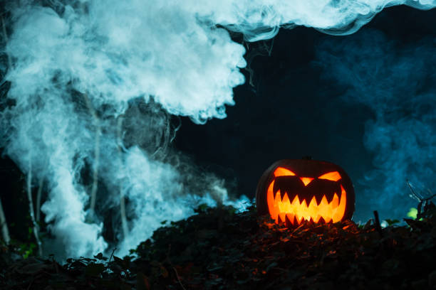istock Scary Illuminated Halloween Pumpkin in Dark Smoky Background 847198758
