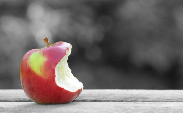 istock Bitten apple on a woden table in garden with copy sapace 847198888