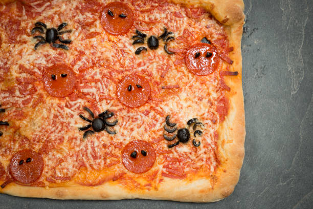istock Halloween-Themed Pizza with Spider-Shaped Pepperoni and Olives Copy Space 847202258