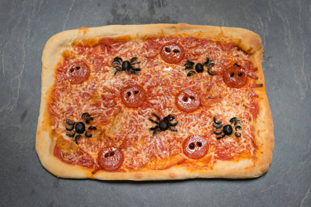 istock Whole Rectangle Halloween-Themed Pizza with Spider-Shaped Pepperoni and Olives 847202310