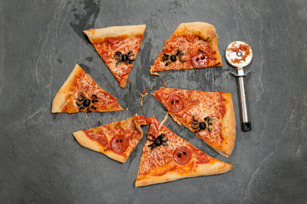 istock Halloween-Themed Pizza Cut Into Portions Alongside a Pizza Cutter 847202322
