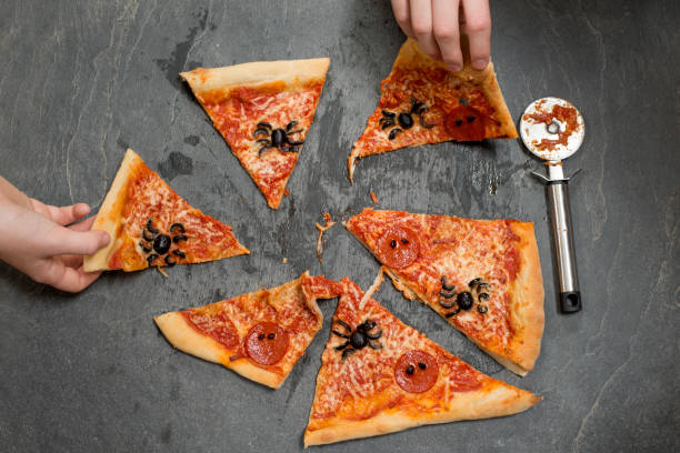 istock Two Hands Picking Up Slices of Halloween Pizza 847202326