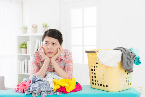 istock unhappy attractive woman maid folding clothes 847203028