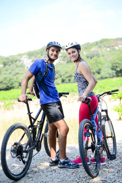 istock happy young couple riding bicycle in countryside during summer 847203076