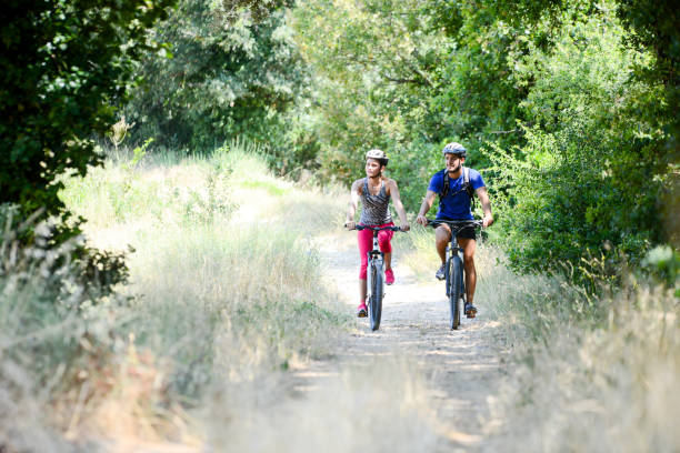 istock happy young couple riding bicycle in countryside during summer 847203192