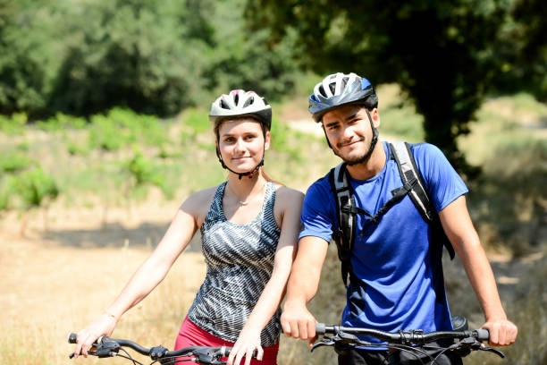 istock happy young couple riding bicycle in countryside during summer 847203378