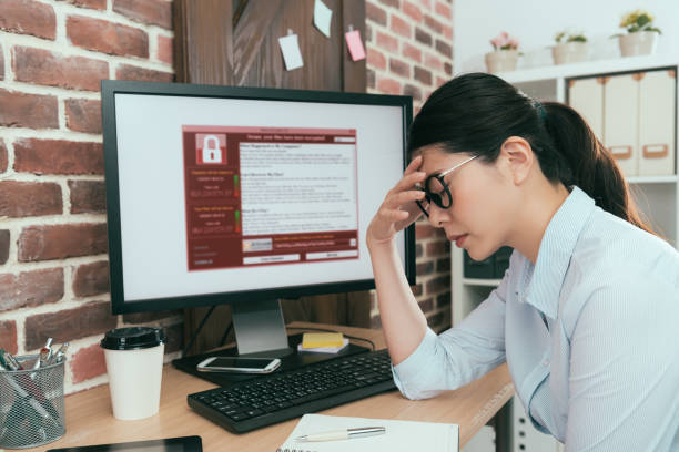 woman finding computer getting virus attack sadness company agent woman finding working computer getting blackmail virus attack thinking solution at office desk and feeling depression. ransomware photos stock pictures, royalty-free photos & images