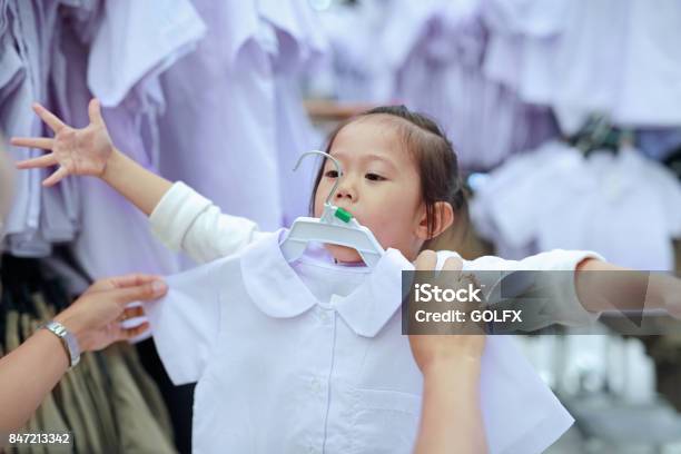 Mother Try Dressing School Uniform For Her Daughter Kindergarten Children Stock Photo - Download Image Now