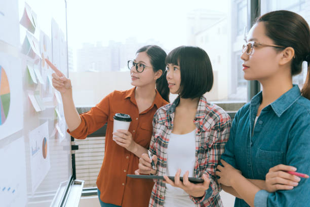 istock business people standing in front of whiteboard 847217596