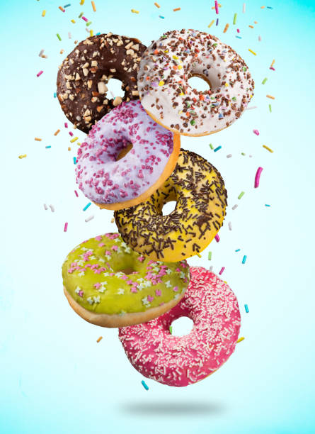 istock Tasty doughnuts in motion falling on pastel blue background 847218736