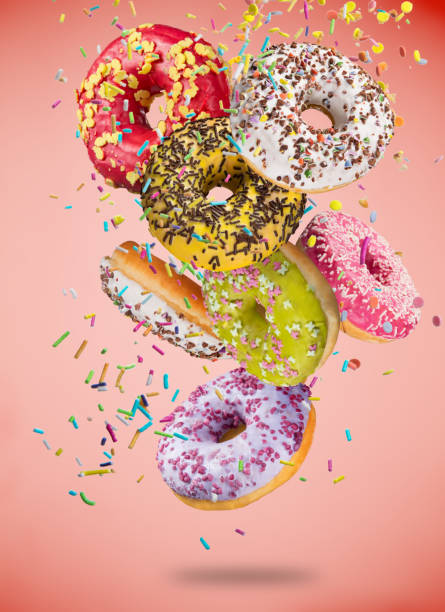 istock Tasty doughnuts in motion falling on pastel blue background 847218828