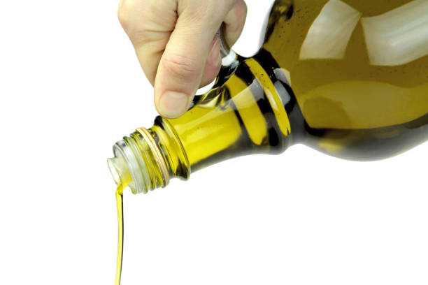 istock Pouring extra virgin olive oil from glass bottle 847222720