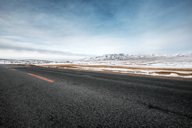istock empty asphalt road with snow mountains in blue sky 847223228